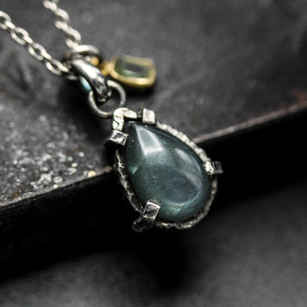 Tiny teardrop cabochon labradorite pendant necklace in silver bezel and prongs setting with green tourmaline gemstone