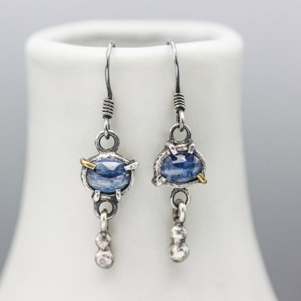 Oval blue kyanite earrings in silver bezel and prongs setting with silver beads on oxidized sterling silver hooks style