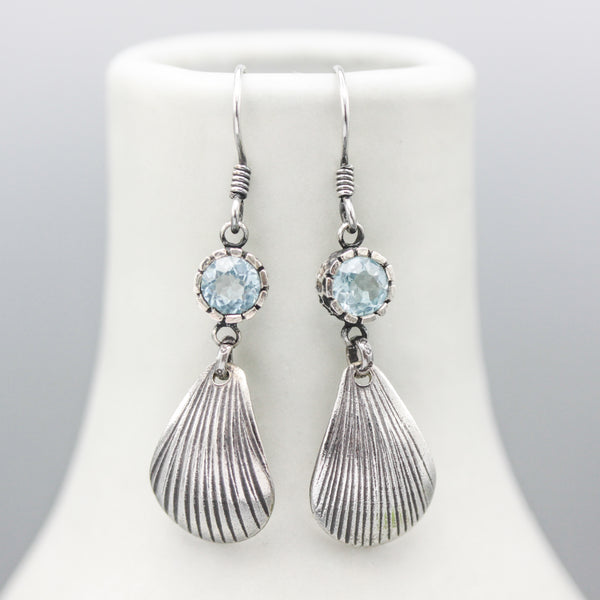 Blue topaz earrings in silver bezel setting with sterling silver shell shape on silver hooks style