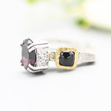 Oval faceted garnet ring in silver bezel and double prongs setting with green tourmaline on the side on sterling silver hammer texture band