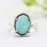 Oval turquoise ring in silver bezel and prongs setting with sterling silver oxidized hammer texture band