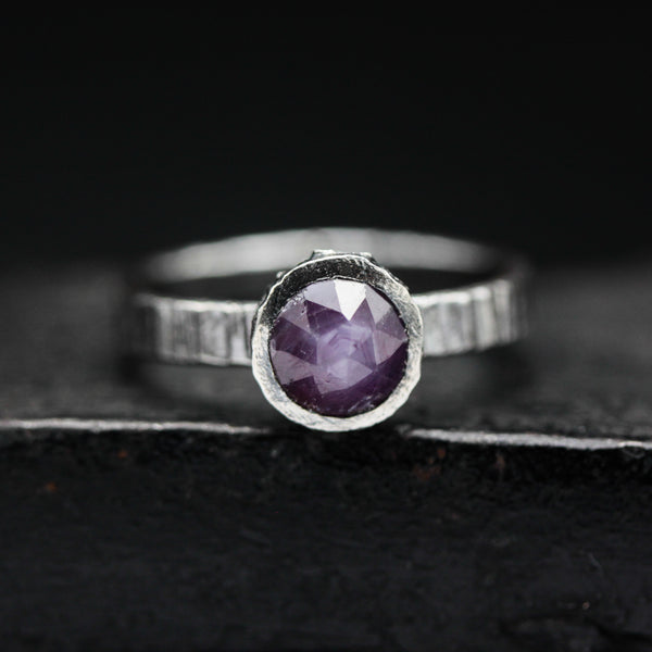 Round faceted pink sapphire ring in bezel setting with sterling silver texture band