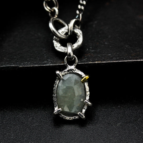 Oval faceted sapphire pendant necklace in silver bezel and prongs setting