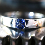 Wedding band ring with blue sapphire on white gold in high polished band