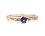 Round faceted blue sapphire ring in prongs setting with tiny diamonds on 14k Rose gold texture design band