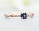 Round faceted blue sapphire ring in prongs setting with tiny diamonds on 14k Rose gold texture design band