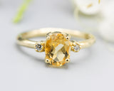 Oval faceted citrine ring with tiny round diamonds side set gems in prongs setting with 14k gold half round band