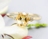 Oval faceted citrine ring with tiny round diamonds side set gems in prongs setting with 14k gold half round band
