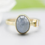 Oval blue star sapphire ring and diamond secondary with 18k gold texture band