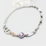 Pink sapphire pendant bracelet with oval pink sapphire gemstone and silver leaf on sterling silver chain