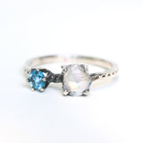 Faceted moonstone ring in silver bezel setting and blue topaz on the side with sterling silver band - Metal Studio Jewelry