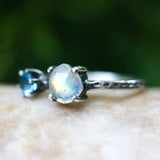 Faceted moonstone ring in silver bezel setting and blue topaz on the side with sterling silver band - Metal Studio Jewelry