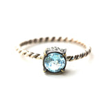 Round faceted blue topaz ring in silver bezel and brass prongs setting with sterling silver twist design band - Metal Studio Jewelry