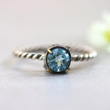 Round faceted blue topaz ring in silver bezel and brass prongs setting with sterling silver twist design band - Metal Studio Jewelry