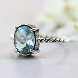 Oval faceted Swiss blue topaz ring in silver bezel and prongs setting on sterling silver oxidized twist design band - Metal Studio Jewelry