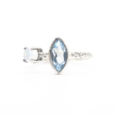 Marquis faceted blue topaz ring in silver bezel setting and round moonstone on the side with sterling silver hard texture band - Metal Studio Jewelry