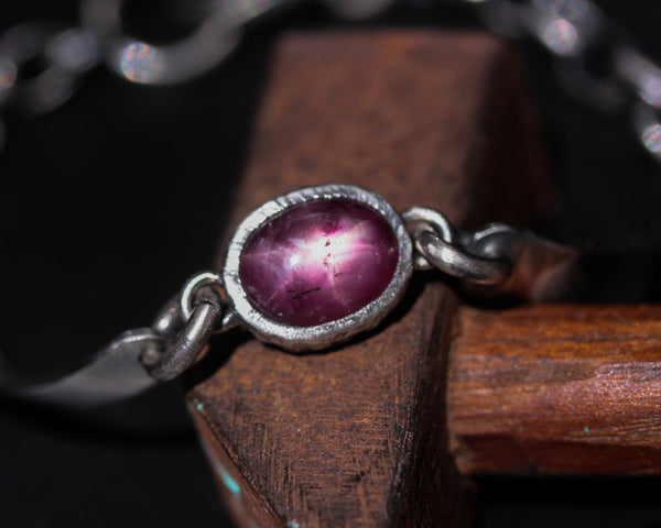 Oval cabochon star ruby bracelet in silver bezel setting and sterling silver oxidized chain