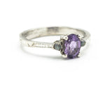Oval faceted amethyst ring with tiny labradorite side set gems in prongs setting with sterling silver texture oxidized band