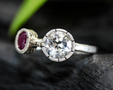 Round faceted white topaz ring in silver bezel setting and tiny ruby on sterling silver hammer texture band