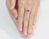 Oval faceted amethyst ring with tiny labradorite side set gems in prongs setting with sterling silver texture oxidized band