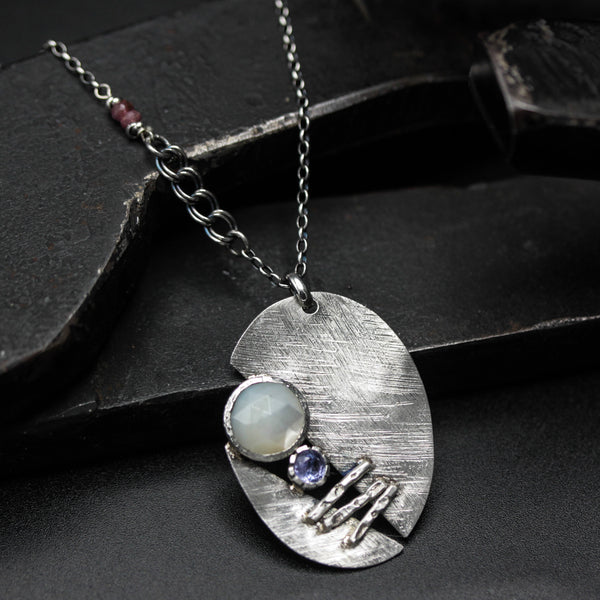 Sterling silver oval shape pendant necklace with white moonstone and tanzanite gemstone in bezel setting on sterling silver chain