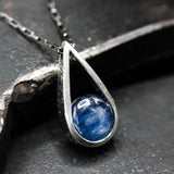 Silver teardrop pendant necklace with round cabochon blue kyanite gemstone on oxidized sterling silver chain