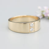 Men's ring in 18k gold featuring a high-polished band with 2 round faceted diamonds.