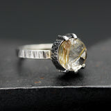 Round faceted golden rutilated quartz ring in silver bezel and prongs setting in sterling silver texture oxidized band