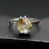 Round faceted golden rutilated quartz ring in silver bezel and prongs setting in sterling silver texture oxidized band