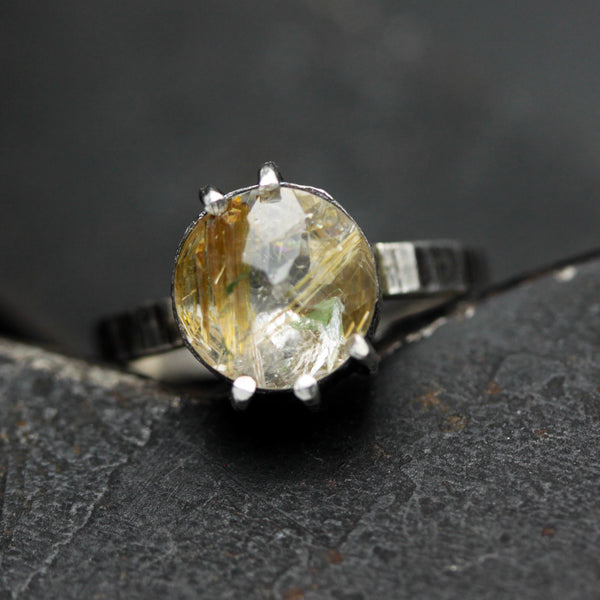 Round faceted golden rutilated quartz ring in silver bezel and prongs setting in sterling silver texture oxidized band