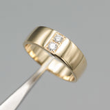 Men's ring in 18k gold featuring a high-polished band with 2 round faceted diamonds.