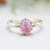 Oval pink sapphire ring in prongs setting with sterling silver hammer texture band