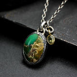 Oval turquoise pendant necklace in silver bezel setting with green multi-sapphire gemstone