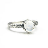 Tiny oval moonstone ring in silver prongs setting with sterling silver hard texture oxidized band