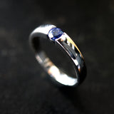 Wedding band ring with blue sapphire on white gold in high polished band