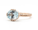 Blue topaz cocktail ring in prongs setting with 14k rose gold texture design band