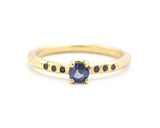 Round faceted blue sapphire ring in prongs setting with tiny black spinel on 14k gold geometric design band