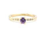 Round faceted amethyst ring in prongs setting with tiny diamonds on 14k gold wood texture design band