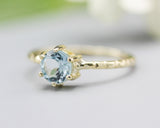 Round faceted blue topaz ring in prongs setting with 14k gold texture design band