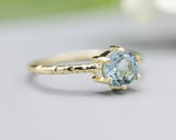 Round faceted blue topaz ring in prongs setting with 14k gold texture design band