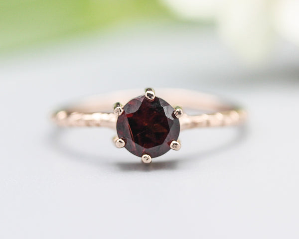 Round faceted garnet ring in prongs setting with 14k rose gold texture design band