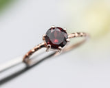 Round faceted garnet ring in prongs setting with 14k rose gold texture design band