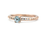 Round faceted blue topaz ring in prongs setting with tiny diamonds on 14k Rose gold texture design band