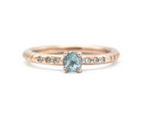 Round faceted blue topaz ring in prongs setting with tiny diamonds on 14k Rose gold texture design band