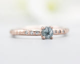 Round faceted blue topaz ring in prongs setting with tiny diamonds on 14k Rose gold texture design band