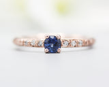 Round faceted blue sapphire ring in prongs setting with tiny diamonds on 14k Rose gold texture design band