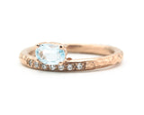 Oval faceted blue topaz ring in prongs setting with tiny diamonds on 14k Rose gold texture design band