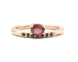 Oval faceted garnet ring in prongs setting with tiny black spinel on 14k Rose gold texture design band