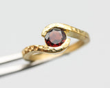 Bypass style ring 14k gold hammer texture design with round faceted Garnet at the center