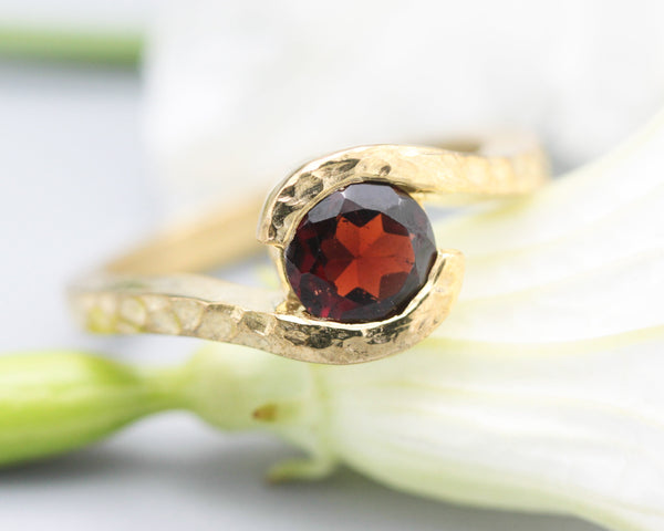 Bypass style ring 14k gold hammer texture design with round faceted Garnet at the center